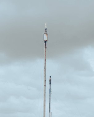 Fırtınalı gökyüzü, eski gaz patlamaları ya da kablolarla desteklenen adam kabloları, San Antonio, Teksas 'taki ham petrol rafinerisinin dumanı, ana kaynak hava kirleticileri rafine petrol. ABD