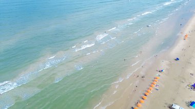 Güney Padre Adası 'ndaki South Beach' in kumlu kıyı şeridi boyunca renkli bir sıra plaj şemsiyesi. Sadece Teksas 'ta tropik bir ada. Temiz zümrüt su. İnsanlar yüzmeyi, sörf yapmayı, hava manzarasını seviyor. ABD