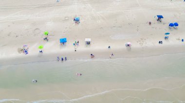Plaj şemsiyesi, çadır, kamp ve şezlong yoğunluğu, çeşitli insanların aileleri yüzmeyi, sörf yapmayı, Padre Adası, Teksas 'ın güney sahillerinde zümrüt sularla dinlenmeyi, hava manzarasını seviyor. ABD
