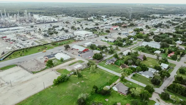 stock image Small agriculture agro-town along highway with large oil refinery complex plant, gas flare, crude oil distillation unit, storage tanks, utility systems, pipelines, San Antonio, Texas, aerial view. USA