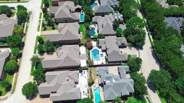 stock image Tall mature trees shade large mansion houses swimming pool, fenced backyard, quite residential street in upscale suburban neighborhood, Coppell, Dallas suburbs DFW Metroplex, Texas, aerial view. USA