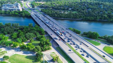 Güney 'den Kuzey Austin' e trafik yoğun saatlerde Colorado Nehri 'ndeki 35 numaralı otoban köprüsünden geçiyor. Travis Heights bölgesinin tahta yolu boyunca yemyeşil ağaçlar var. ABD