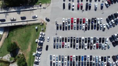 Paralel şablonda park etmiş bir sürü elektrikli ve benzinli araçla dolu büyük otoparktan yürüyen insanlar, kaldırım numarası, Arlington, Texas, üstgeçişi olan modern park yönetimi.