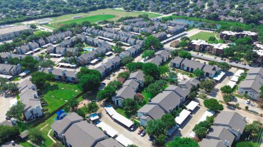 Okul bölgesinde büyük bir apartman kompleksi, kapalı otoparkı, yüzme havuzu, köpek parkı ve göleti olan çok katlı evler, yakınlardaki yerleşim yerleri, hava manzarası. ABD