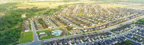 stock image Panorama aerial view lush greenery area suburban residential neighborhood West of San Antonio, Texas, row of new development two story homes shingle roofs, swimming pool, share division fences. USA