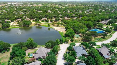 Tenis ve basketbol sahaları, göl kenarındaki göl kenarındaki göl kenarındaki iki katlı evler, yemyeşil orman Keller, Tarrant County, Dallas banliyöleri, hava manzaralı. ABD