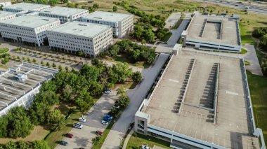 Multi-level garages with rooftop parking lots in suburban office campus buildings near Westlake, Texas, two-way traffic flow maximum spaces utilization, suburb Dallas-Fort Worth metroplex, aerial. USA clipart