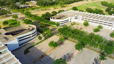 Çatısı olan çok katlı garajların iki yönlü trafik akış rampaları Westlake 'teki modern banliyö kampüs binasının gölgelik yapısını içeriyor. Dallas-Fort Worth banliyösü, anten. ABD