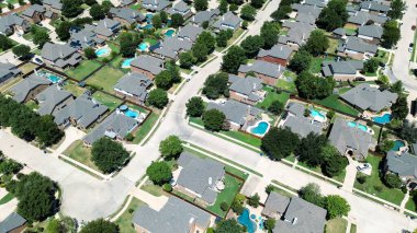 İki katlı banliyö evleri aynı ahşap çitleri paylaşıyor. Olgun ağaçlar, yeraltı yüzme havuzu Keller, Teksas 'ta sakin bir yerleşim sokağı boyunca Dallas Fort Worth banliyöleri, anten. ABD