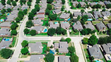 İki katlı banliyö evleri aynı ahşap çitleri paylaşıyor. Olgun ağaçlar, yeraltı yüzme havuzu Keller, Teksas 'ta sakin bir yerleşim sokağı boyunca Dallas Fort Worth banliyöleri, anten. ABD