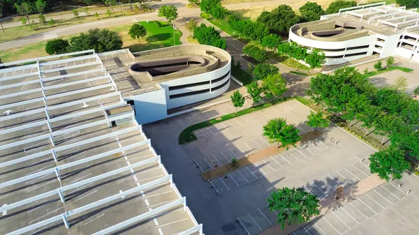 stock image Parking ramp to multilevel garage with rooftop angled parking layout design, shade structure, traffic flow marking at suburban campus building in Westlake, suburbs Dallas Fort Worth, aerial. USA