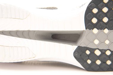 Close-up carbon-plated running racing shoes built with a carbon fiber plate embedded in the midsole isolated on white background, plate reduces fatigue, increases the energy return on each stride. USA clipart