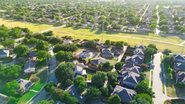 stock image Residential neighborhood near open space trail, concrete pathway boundary with overhead utility right-of-way high voltage power lines in West Plano, suburbs Dallas, lush tree lined street, aerial. USA