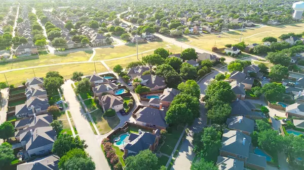 stock image Residential neighborhood near open space trail, concrete pathway boundary with overhead utility right-of-way high voltage power lines in West Plano, suburbs Dallas, lush tree lined street, aerial. USA