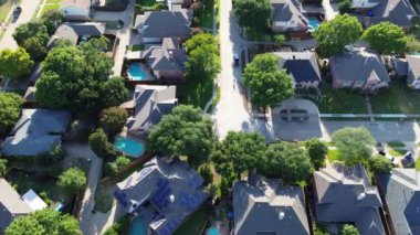 Batı Plano, Teksas 'taki lüks yerleşim yerlerinin köşesindeki banliyö güneş panelleri, iki katlı banliyö evi yemyeşil ağaçlar, temiz enerji, Dallas Fort Worth Metroplex banliyöleri, üstgeçit.