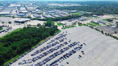 Busy parking of gas and electric vehicles in large outdoor garage near entertainment district South of Arlington, row warehouse fulfillment center, supply chain hub logistics industrial, aerial. USA clipart