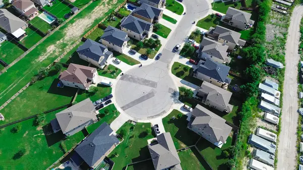 stock image Two-story suburban houses with large grassy backyard, front drive way in New Braunfels, Texas near row of fiberglass prefab pools manufacturer, cul-de-sac dead-end keyhole shape street, aerial. USA