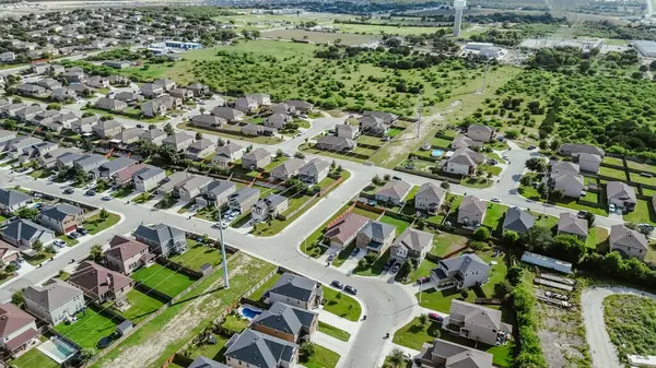 stock image Quiet residential street in new construction houses community suburbs San Antonio, row of two story suburban single-family homes in urban sprawl encroachment with vacant land for growth, aerial. USA