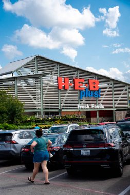 SCHERTZ, TX, US-JUL 25, 2024: Müşteri yoğun otoparklardan H.E.B Plus marketine giriyor, güneşli mavi gökyüzü, San Antonio merkezli özel süpermarket zinciri ABD, Meksika 'da 380' den fazla mağaza