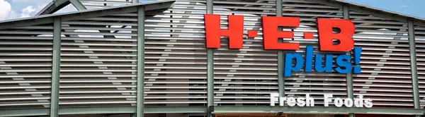 stock image SCHERTZ, TX, US-JUL 25, 2024: Panorama view 3D raised letter LED signage billboard at facade entrance of H.E.B Plus grocery store, San Antonio private supermarket chain more 380 stores in USA, Mexico