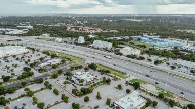 I-35 otoyolu, Monarch Hwy üst geçidi, arka planda Austin şehir merkezi, hızla büyüyen Kuzey Austin karma kullanım alanı, modern apartman kompleksi, büyük alışveriş merkezi, iş parkı, anten. ABD
