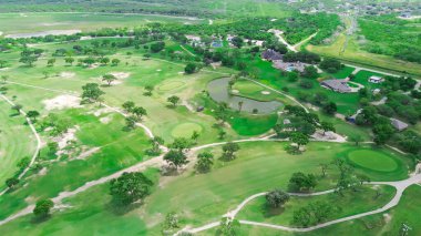 Hazel Park, Corpus Christi, Güney Teksas yakınlarındaki bir golf sahasında kum tuzağı ve gölet. Yüzme havuzlu, çimenli arka bahçeli, uzun ağaçlı, antenli yerleşim yerlerini çevreleyen evler. ABD