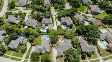 Large suburban two-story houses with swimming pool, wooden backyard grassy lawn, lush greenery mature trees in upscale neighborhood of Keller, suburbs Dallas Fort Worth metroplex, Texas, aerial. USA clipart