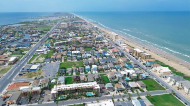 Sahil şeridi sakin dalgalar Güney Padre Adası, Teksas, rengarenk plaj evleri yüzme havuzları, rıhtım evleri, tatil yerleri, kiralık tatiller, insanlar yüzme, antenler. ABD