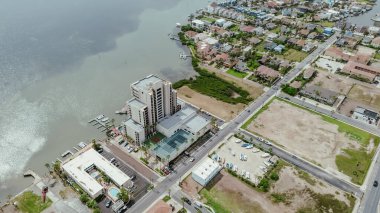 Rıhtıma yakın sahil evleri, oteller, yüksek katlı apartmanlar, Teksas, tropikal Güney Padre Adası 'nın tatil kiraları, Laguna Körfezi boyunca yoğun miktarda yosun, anten. ABD