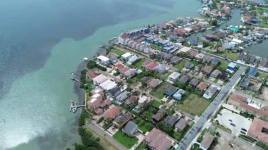 Güney Padre Adası 'ndaki Laguna Körfezi' nde yoğun yosun yoğunluğu, özel jetty erişimi olan yüksek sahil dairesi, yüzme havuzları, tenis kortları, kiralık tatiller, renkli evler, üstgeçit.