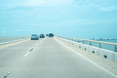 Queen Isabella Memorial Köprüsü 'nde yoğun trafik ya da Gulf Coast üzerindeki Kraliçe Isabella Causeway şehir merkezindeki Güney Padre Adası binaları Port Isabel' den beton iskele-kiriş köprüsü. ABD