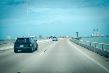 Queen Isabella Memorial Köprüsü 'nde yoğun trafik ya da Gulf Coast üzerindeki Kraliçe Isabella Causeway şehir merkezindeki Güney Padre Adası binaları Port Isabel' den beton iskele-kiriş köprüsü. ABD