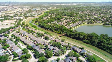 Coppell Teksas banliyö parkı yemyeşil ağaçlar, göl, dere iki katlı havuzlu evler, karşılıklı yığınlar ve arka planda Dallas şehir merkezi, anten. ABD