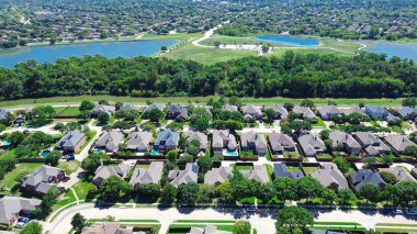 Büyük göl, gölet, yemyeşil banliyö parkında yürüyüş yolları Dallas Fort Worth Metroplex 'in varoşlarında, yüzme havuzlu, antenli bir sıra bağımsız aile evi. ABD