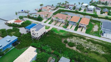 Sel yönetimi ve lüks villa malikaneleri için ayaklıktaki yazlık evler özel ahşap iskeleli tekne rampası, Laguna Körfezi Güney Padre Adası, konut alanı ve kiralık tatil alanı, anten. ABD