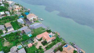 Laguna Körfezi 'nde, lüks malikanelerin, plaj villalarının yanında siyah yosun yosunu yüzme havuzlu tatil kirası Güney Padre Adası' nda ahşap iskele, palmiye ağaçları, Texas, anten. ABD