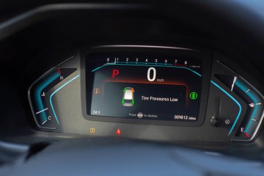 Yakın çekim lastik basıncı düşük göstergesi modern araba minivanı panelinde park modunda, lastik basıncı izleme sistemi TPMS sürücü bilgi arayüzünde ışık olduğunu gösteriyor. ABD
