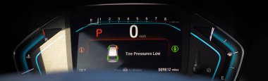 Panorama view tire pressure low indicator display on instrument panel of modern car minivan in Parking mode, tire pressure monitoring system TPMS indicates lights on driver information interface. USA clipart