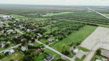 U.S. Highway 281 along agriculture agro-town with residential houses, church buildings, small local business, large farmland ranch in Three Rivers, Texas, suburban rural scene, small town aerial. USA clipart