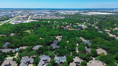 Upscale residential neighborhood lush greenery area with city water tower, dense of warehouse fulfillment distribution center in background, mixed-use development area, Dallas Fort Worth aerial. USA clipart