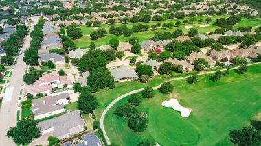 Golf sahasında geniş meskenli evler çimenli çayırları olan, Batı Plano, Teksas 'ta kum kapanı olan iki katlı banliyö evleri Dallas banliyölerinde yüzme havuzları olan, antenli. ABD