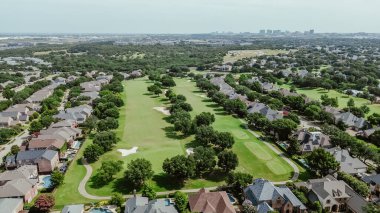 Panorama hava manzaralı şehir merkezi arka planda Plano Texas şehir merkezi, çimenli golf sahası, kum kapanı sığınakları, iki katlı yüzme havuzu olan bir şehir kulübü. ABD