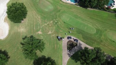 Golfçüler ve golf sahasından çıkıp kulüp arabalarına giden golf sopası taşıyıcıları, soğutucuyu bırakıp Plano 'nun varlıklı yerleşim yerlerinde, Dallas' ın banliyölerinde, üstgeçitte bulunan şehir kulübünü terk edenler.