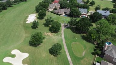 Kum çukurları golf sahası ve Teksas, Plano 'daki lüks golf klübünde oynayan meşgul golfçüler, kulüp vagonu, varlıklı yerleşim yerlerinde yer alan açık hava eğlence alanı, üstgeçit.