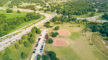 Kalabalık arabalar North Buckner Bulvarı ve Kuzeybatı Karayolu boyunca Norbuck Park 'ın yakınındaki yemyeşil yeşil otlaklar çimenli çimler, LED ışık direkleri, White Rock Dallas, anten. ABD