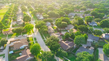 Coppell Texas Dallas Fort Worth Metroplex 'teki yeşil sıfır emisyon kentsel tasarım mahallesinde gün batımı. Bir sıra bağımsız tek aile yüzme havuzları, büyük arka bahçe, çimenlik çimenlik, hava antenleri. ABD