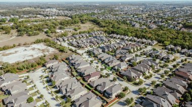 Bartonville 'de, Denton County, Teksas yakınlarındaki yerleşim yerlerinde büyümek üzere kentsel genişleme arazisi. İki katlı banliyö evi, güneş çatısı, yemyeşil kuşak kentsel orman, anten. ABD
