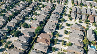 Row of suburban houses with shingle roofings along parallel tree lined residential street in upscale new neighborhood in Argyle, Denton County, Texas, fast growing area Dallas suburbs, aerial. USA clipart