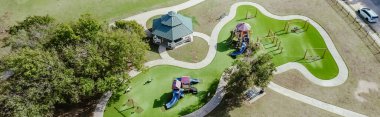 Panorama view residential neighborhood parked car on street near playground artificial turf, pavilion and climbing, sliding structure at community recreational facility, playing structure, Dallas. TX clipart