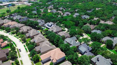 İki katlı, uzun boylu, olgun ağaçlarla çevrili iki katlı evler Coppell 'deki lüks yüzme havuzları Dallas Fort Worth Metroplex, Teksas' ın banliyöleri, antenler. ABD